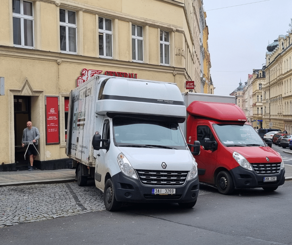 Firemní vozidlo stojící před vchodem do Generali v Karlových Varech. 